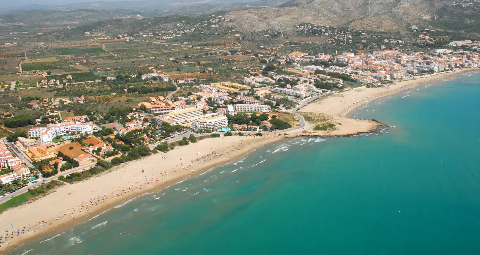 Luftaufnahme des Strandes Cargador und des Strandes Playa Romana in Alcossebre mit der Serra d'Irta dahinter